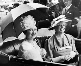 Mrs. Eleanor Roosevelt and Queen Elizabeth, holding umbrella, in automobile, leaving station for the White House.