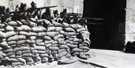 Nationalist soldiers fight behind a barricade during the Spanish Civil War