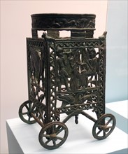 bronze wheeled stand, designed to support a bowl or incense burner used in a ceremony or feast