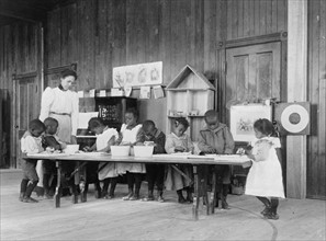 African American children learning laundry care in kindergarten