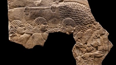 Servants carrying dead lion. Wall frieze, Assyrian, about 645-635 BC