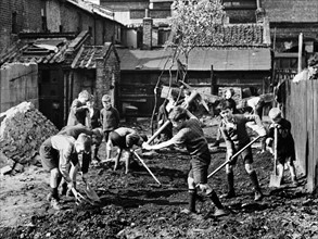 Boys clear away the debris in England, World War Two, 1943