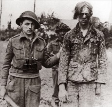 Photograph of a captured Hitler Youth member with Canadian soldiers