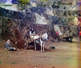Colour photograph of a family with horse-drawn carts, working in the iron mines n the Bakaly Hills of Russia's Ural Mountains