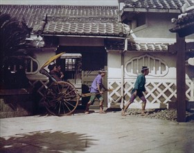 Hand-coloured photograph of Japanese women being carted around by Felice Beato