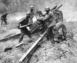US Army artillery crew firing a 105 millimetre howitzer, during the Korean War 1950