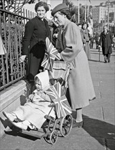 World War two: Women, with a child in a pram, New Zealand VE day, May 1945