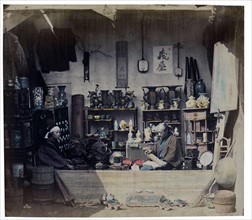 felice beato; Photograph of a Japanese shop with owners 1880
