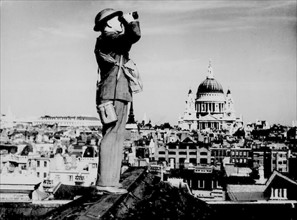 Air Raid or aircraft spotter on the roof of a building near St. Paul's Cathedral , London, during World war Two.