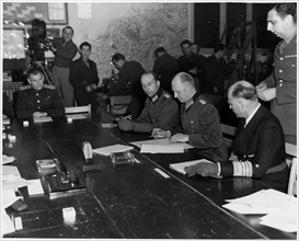 Photograph of Alfred Jodl signing a document of unconditional surrender