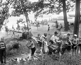 boys carrying loaves of bread from wagons near beach in North America