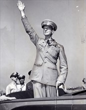 General Wainwright, standing in car, waving to crowd gathered at La Guardia