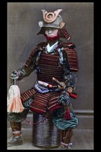 Hand-coloured photograph of a Japanese warrior or Samurai with body tattoos. Photographed by Felice Beato