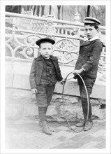 Two boys playing with circular hoops c1900