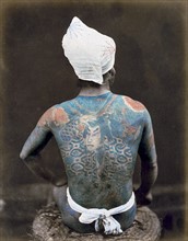 Hand-coloured photograph of a Japanese man with back tattoo Photographed by Felice Beato