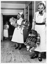 Photograph of nurses testing gas masks on babies at an English hospital