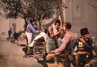 Colour photomechanical print of Barbers near Seraskierrat, Constantinople, Turkey