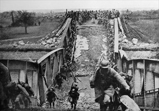 World war One: French troops climb across a ruined bridge 1915