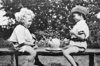 Vintage photograph of two children on a bench with a watermelon 1925