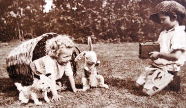 Vintage photograph of two children playing with toys in an English garden 1928