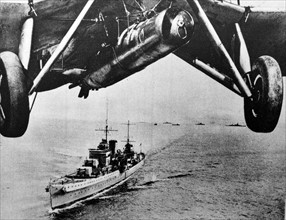Aircraft flies above a battle cruiser of the British Royal Navy 1930's