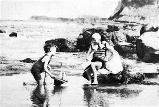Young boys paly in a tidal pool on an English beach 1928