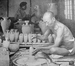 Japanese potter painting a vase