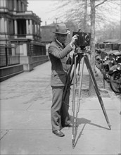 Man using a motion picture camera on a tripod