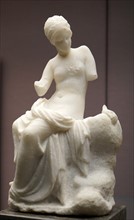 Marble statuette of a woman seated on a rock