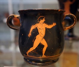 Ancient Greek red on black mug depicting an Athlete