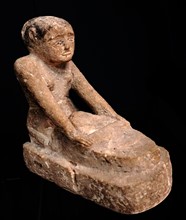 Limestone statuette of a servant grinding grain
