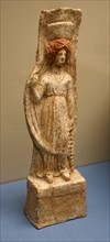 Terracotta figure of a woman wearing a chiton and Polos crown