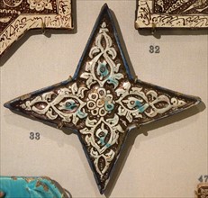 Four-pointed lustre star tile with moulded decoration from Iran