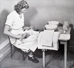 a nurse changing and cleaning a new-born baby