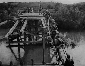 Serbian soldiers cross a temporary bridge at the river koloubara.