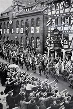 Armed forces Day in Nuremberg, 1935; Soldiers parade while onlookers give Nazi salute.