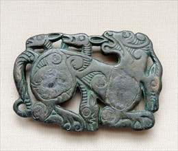 Bronze harness plaque in the form of a tiger attacking an ibex.