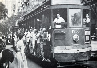 Busy street scene in Rio de Janeiro, Brazil as people crowd a tram