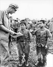 Photograph of an American Marine and Japanese Child Soldiers