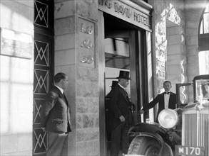 Photograph of Lord Earl Peel entering his car from the main entrance of King David Hotel