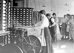 Photograph of young woman at spinning machine in cotton mill