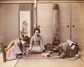 Colour Photograph of two Japanese women greeting another woman with a gift box tied with mizuhiki