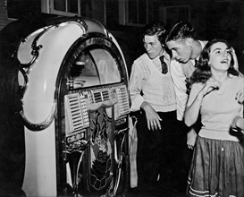 Photograph of young americans gathered next to a Jukebox