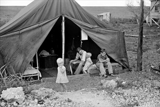 Migrant worker with his children living in a tent during the American Great Depression