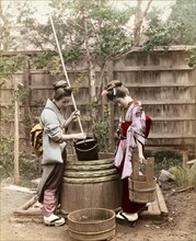Colour photograph of Japanese women drawing water from a well