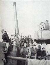 Photograph of the crew members of the British destroyer looking up toward an overhead aircraft