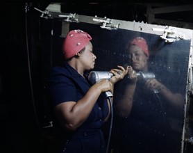 World war two: Woman Operates a hand drill at Vultee-Nashville, working on a 'Vengeance' dive bomber, Tennessee