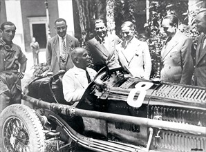 Mussolini sits in an Alfa Romeo racing car