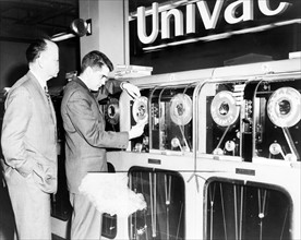 One man looks on as another man prepares Univac computer
