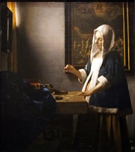 Painting titled 'Woman Holding a Balance' by Johannes Vermeer